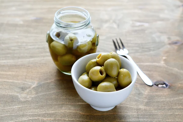 Olives dans un bocal transparent et un bol — Photo