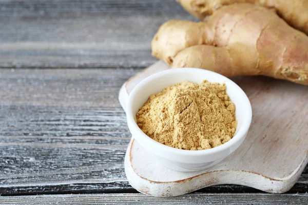 Fresh ginger root with a spicy powder in bowl — Stock Photo, Image