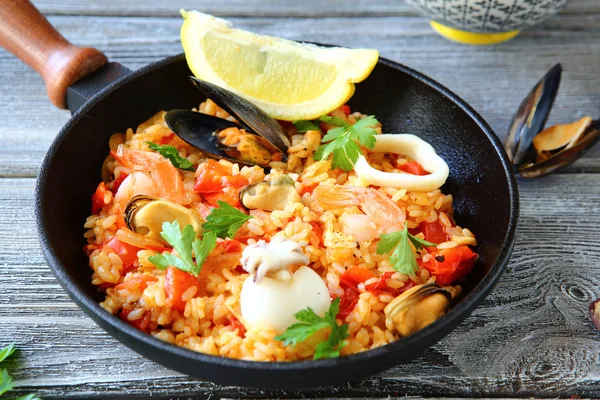 Paella with rice and seafood in a frying pan — Stock Photo, Image