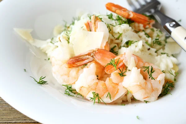 Delizioso risotto con gamberetti e aneto su un piatto — Foto Stock