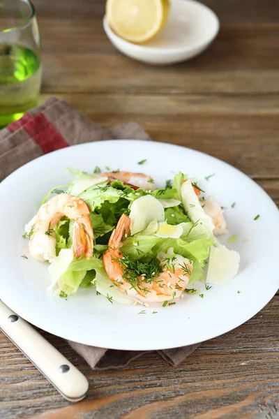 Delicious salad with shrimps, lettuce and cheese on a plate — Stock Photo, Image