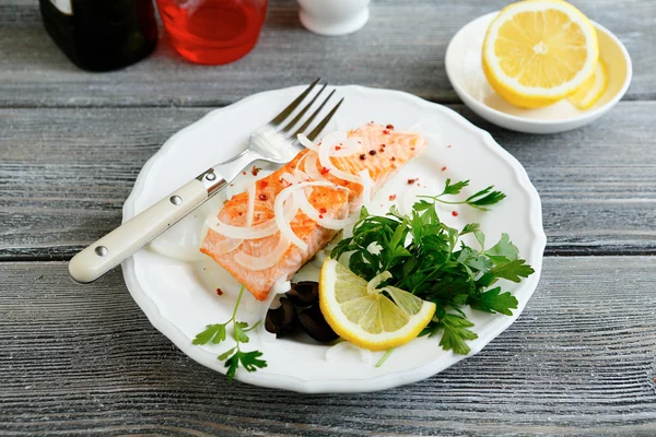 Peixe vermelho com um limão na chapa — Fotografia de Stock