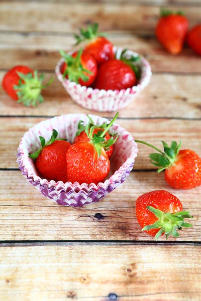 Fresh strawberries in paper cake pans — Stock Photo, Image