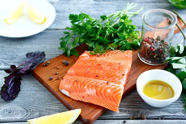 Lachsfilet mit frischen Kräutern und Zitrone auf einem Brett — Stockfoto