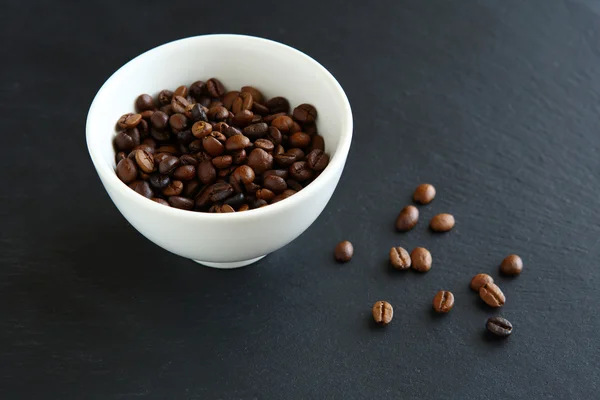 Koffie bonen in een kom op leisteen — Stockfoto