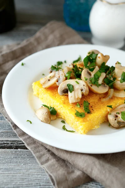 Tasty polenta with mushrooms in a white plate — Stock Photo, Image