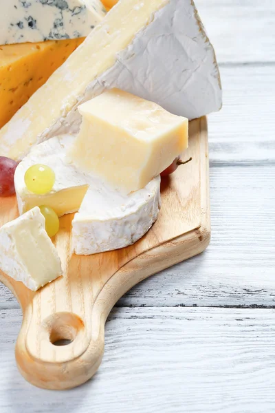 Cheeses on cutting board — Stock Photo, Image