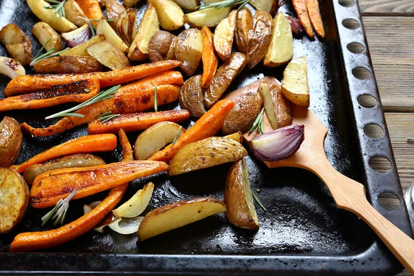 Potatoes with carrots, onions on a baking tray — Stock Photo, Image