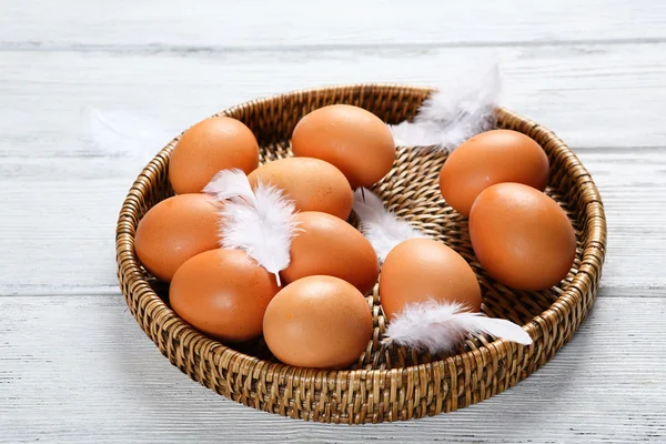 Huevos crudos en una bandeja de mimbre — Foto de Stock