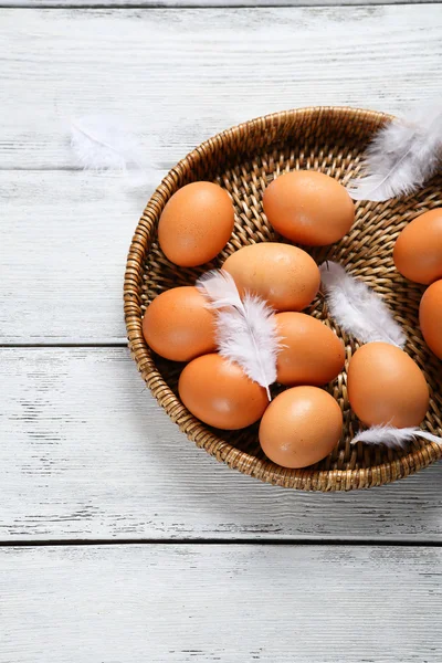 Huevos y plumas en bandeja — Foto de Stock