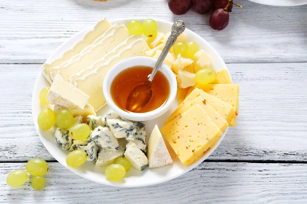 Cheeses with honey and grapes — Stock Photo, Image