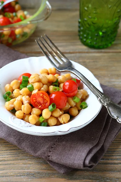 Kikkererwten met tomaten en uien op een plaat — Stockfoto