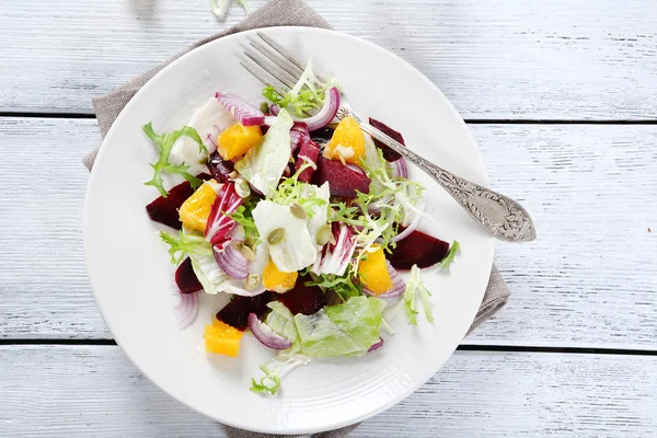 Sallad med lök och apelsiner på en tallrik — Stockfoto