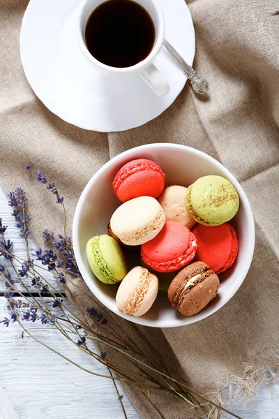 Macaroon em uma tigela com café preto — Fotografia de Stock