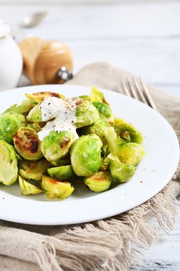 Bir plaka üzerinde soslu Brüksel lahanası kavrulmuş