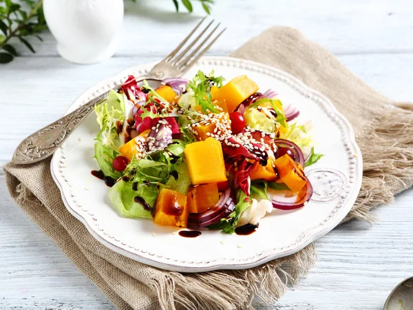 Salad with slices of pumpkin and sesame seeds — Stock Photo, Image