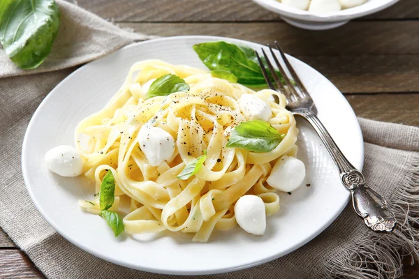 Pasta con mozzarella e basilico su un piatto — Foto Stock