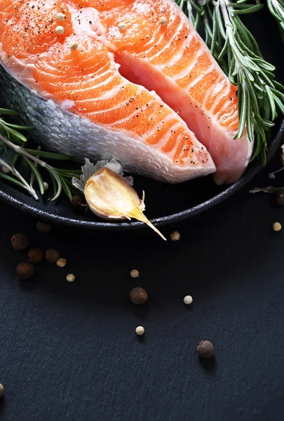 Salmon and spice in pan on slate — Stock Photo, Image
