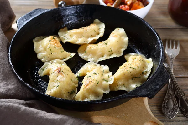 Dumplings with potatoes in a frying pan — Stock Photo, Image