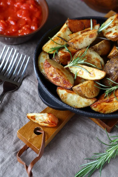 Batatas com ervas em uma panela de ato de fritar — Fotografia de Stock