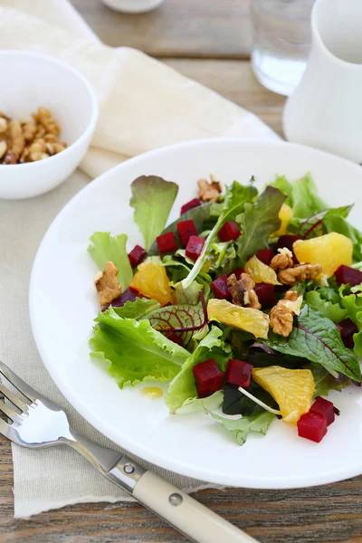 Salada deliciosa com nozes, legumes e laranja — Fotografia de Stock