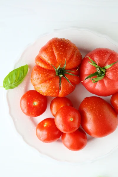 Reife Tomaten auf weißem Teller — Stockfoto