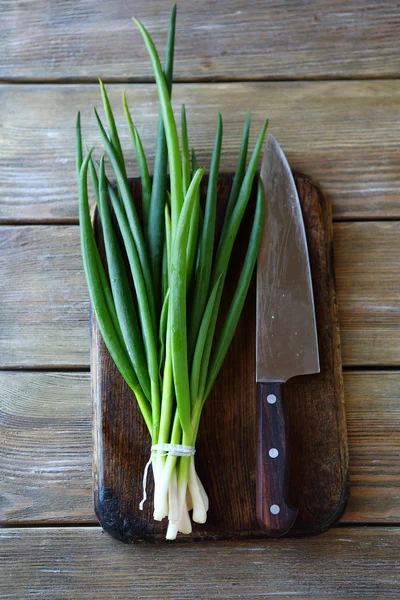 Bund grüne Zwiebel und Messer — Stockfoto