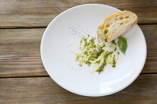Соус песто на тарелке с ломтиком хлеба — стоковое фото