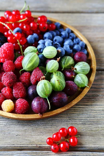 Летние ягоды на деревянной тарелке — стоковое фото