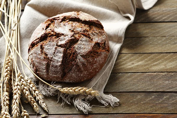 Хліб з вухами пшениці на фоні дощок — стокове фото