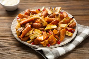 Kavrulmuş havuç ve yaban havucu ahşap yüzeye yakın.