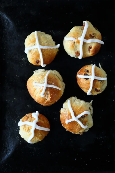 Горячие булочки крест с глазурью на хлебопекарном листе — стоковое фото