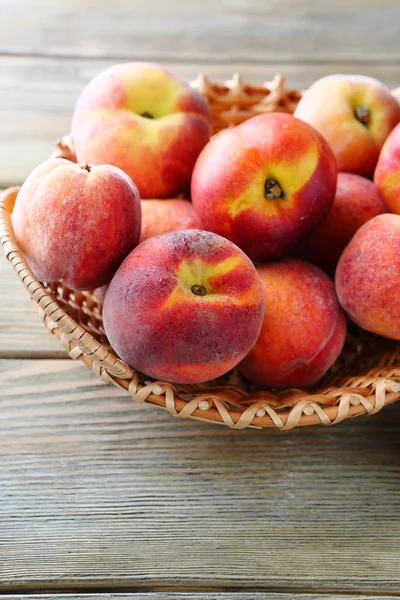 Peaches in wicker basket — Stock Photo, Image