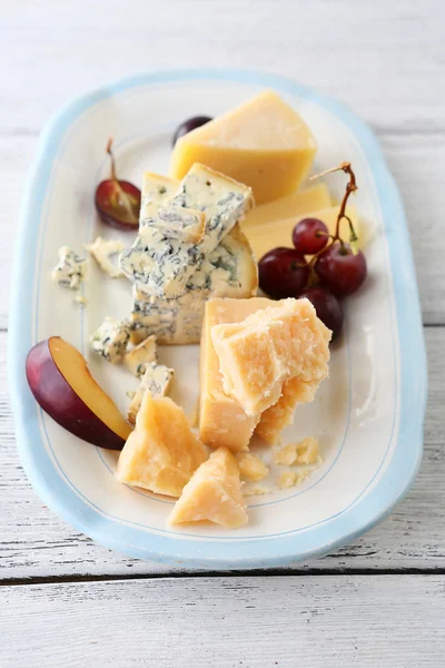 Cheeses and grapes on plate — Stock Photo, Image