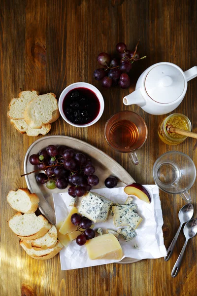 Cheese with grapes on breakfast table — Stock Photo, Image