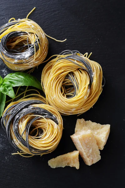 Rå pasta och ost på skiffer — Stockfoto