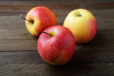 Ahşap arka plan üzerinde kırmızı ve sarı elmalar