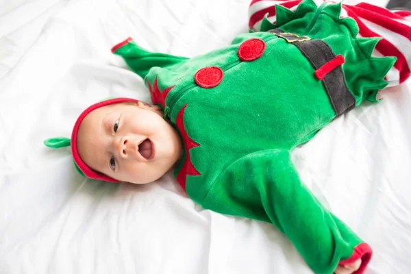 Baby in elf kostuum voor kerstvakantie op witte achtergrond — Stockfoto