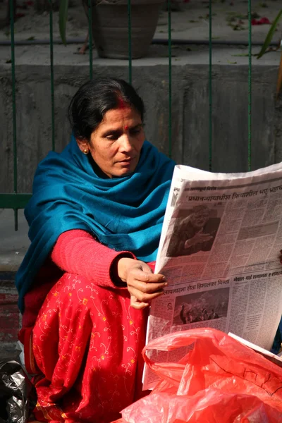 KATHMANDU, NEPAL-DICEMBRE 2009 - Una donna nepalese non identificata che legge il giornale al mattino — Foto Stock