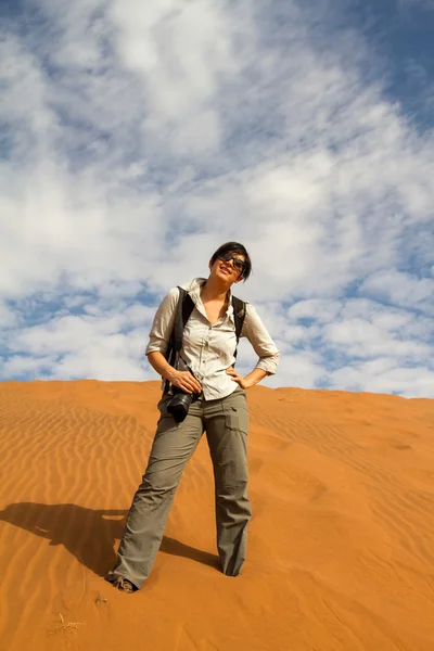 Mulher turista escalando uma duna de areia — Fotografia de Stock