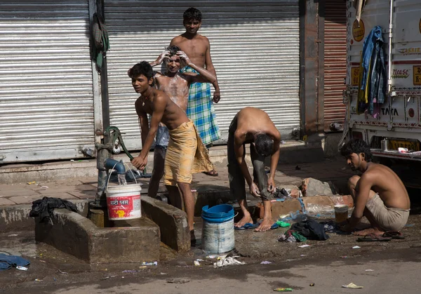 Les jeunes hommes indiens se lavent sur la route Image En Vente