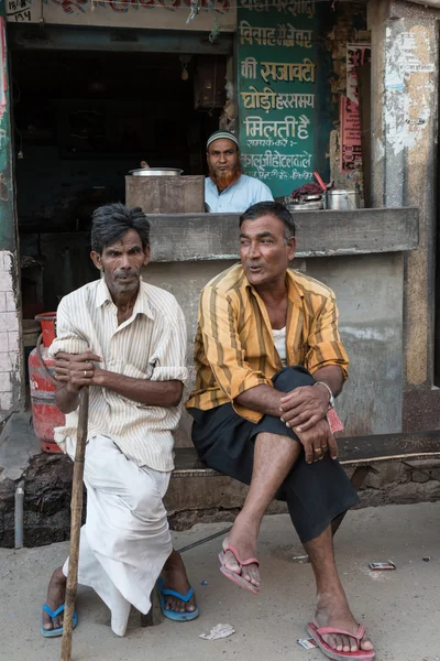 Indische Männer sitzen vor einem Geschäft — Stockfoto