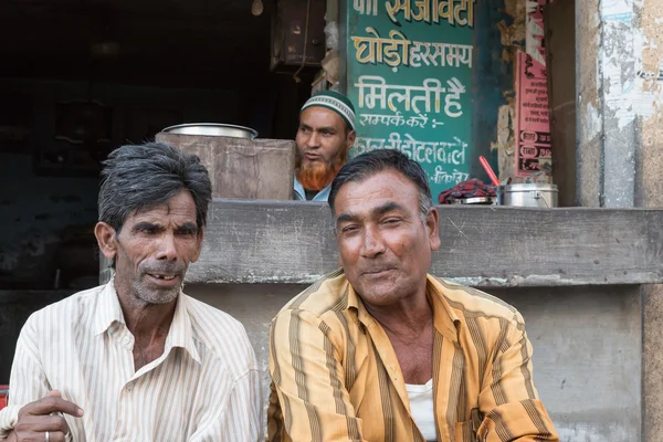 Indische Männer sitzen vor einem Geschäft — Stockfoto