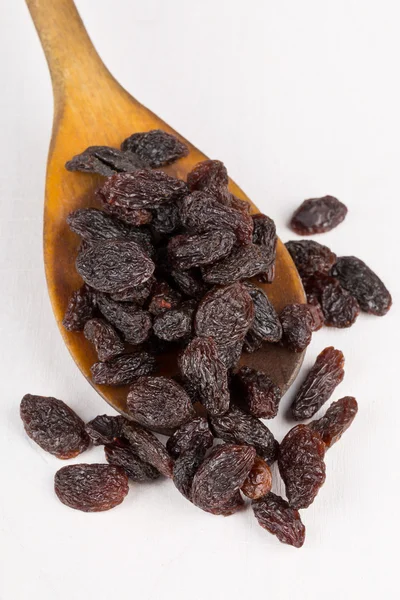 Raisins in wooden spoon on table — Stock Photo, Image