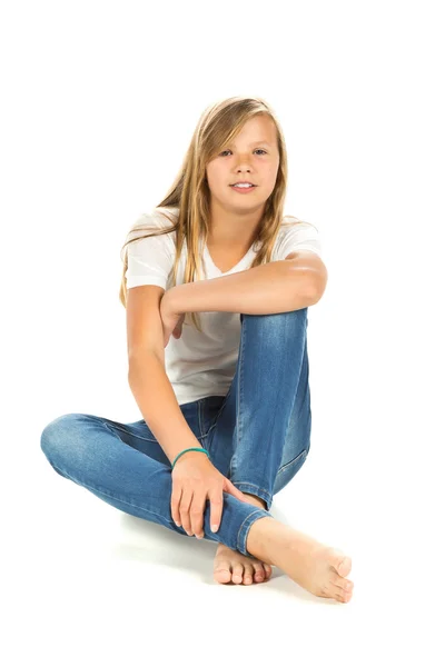 Jovem sentada com t-shirt branca e jeans azul sobre branco — Fotografia de Stock