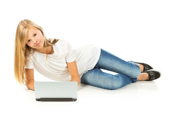 Chica joven acostada en el suelo con el ordenador portátil sobre fondo blanco —  Fotos de Stock