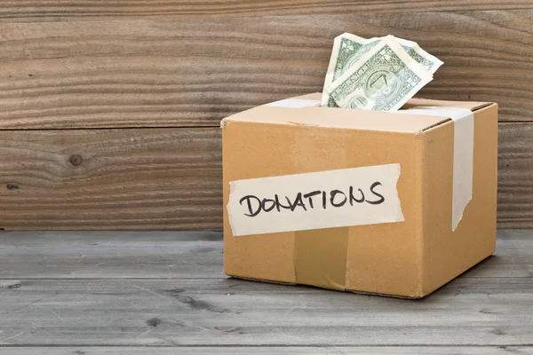 Caja de cartón de donación con billetes en dólares —  Fotos de Stock