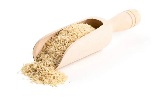 Natural brown uncooked rice in wooden scoop — Stock Photo, Image