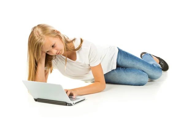 Menina deitada no chão usando laptop sobre fundo branco — Fotografia de Stock