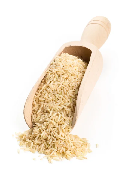 Natural brown uncooked rice in wooden scoop — Stock Photo, Image